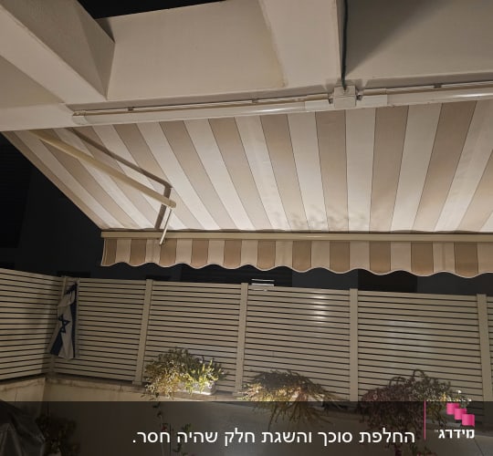 סוכך מותקן מעל גדר עם צמחים